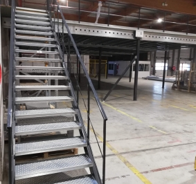 Metalowe schody przemysłowe zainstalowane w magazynie w celu zapewnienia dostępu do platformy
			