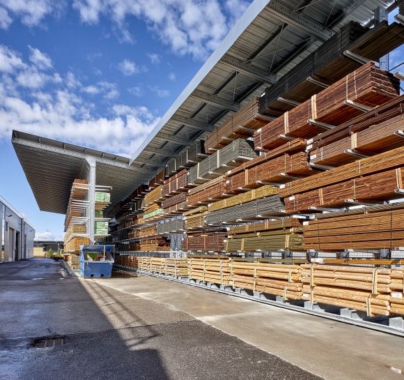 Wysoki poziom składowania drewna na zewnętrznych regałach wspornikowych wyposażonych w zadaszenia
					                    